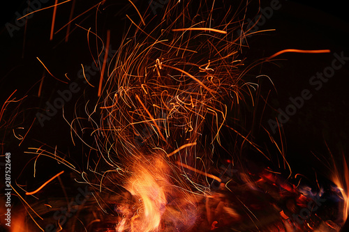Fire, flame on a black background, burning coals and sparks from the fire, motion blur. Close-up. Abstract background.