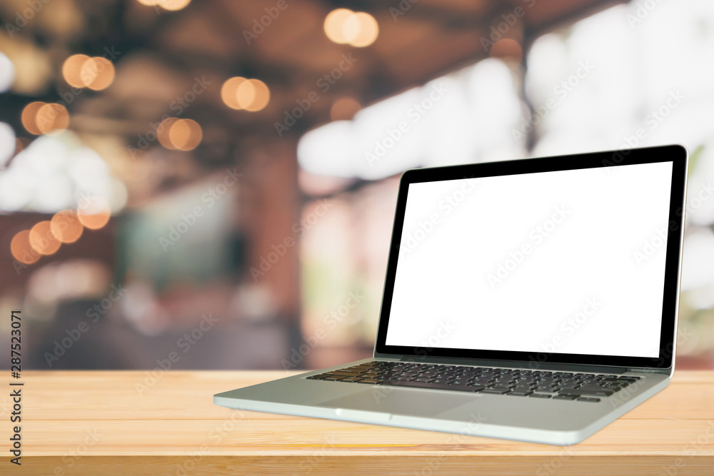 Blank white screen laptop computer on wood table top with cafe restaurant abstract bokeh light defocused blur background Blank white screen laptop computer on wood table top with cafe restaurant abstract bokeh light defocused blur background