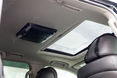 View to the interior of car with rear passenger entertainment system dvd and sunroof after cleaning before sale on parking © Aleksandr Kondratov
