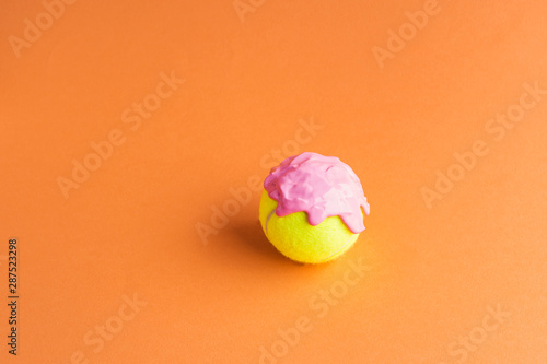 Tennis ball with pink paint on orange