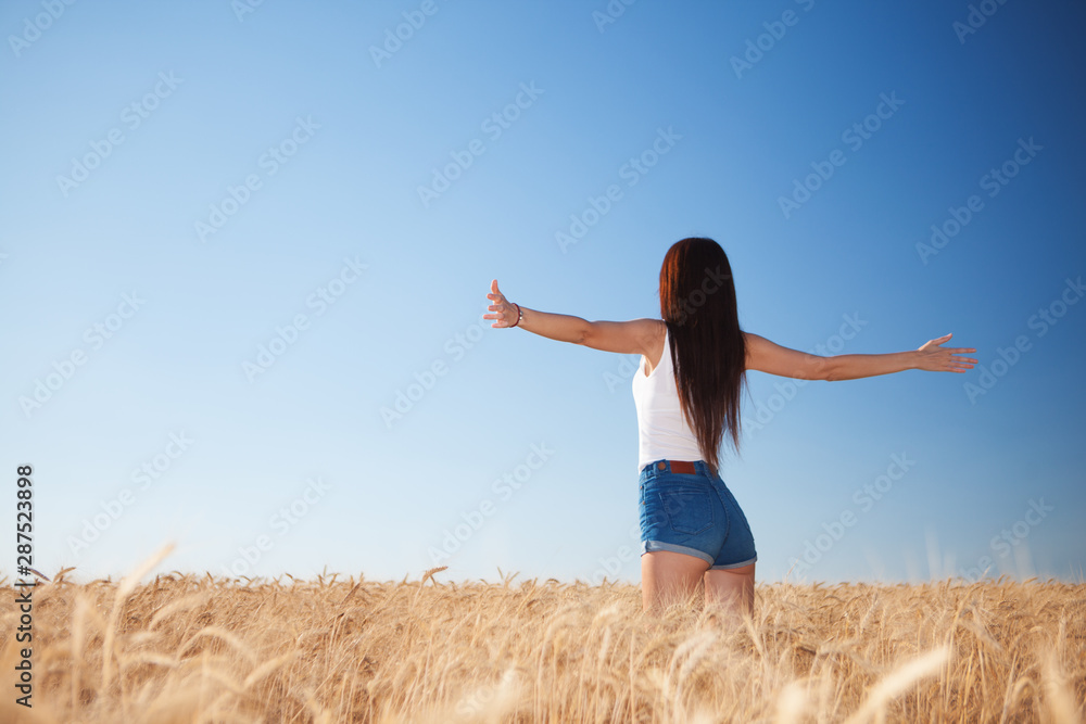 Happy woman enjoying the life in the field. Nature beauty, blue sky,white clouds and field with golden wheat. Outdoor lifestyle. Freedom concept. Woman jump in summer field Happy woman enjoying the life in the field. Nature beauty, blue sky,white clouds and field with golden wheat. Outdoor lifestyle. Freedom concept. Woman jump in summer field