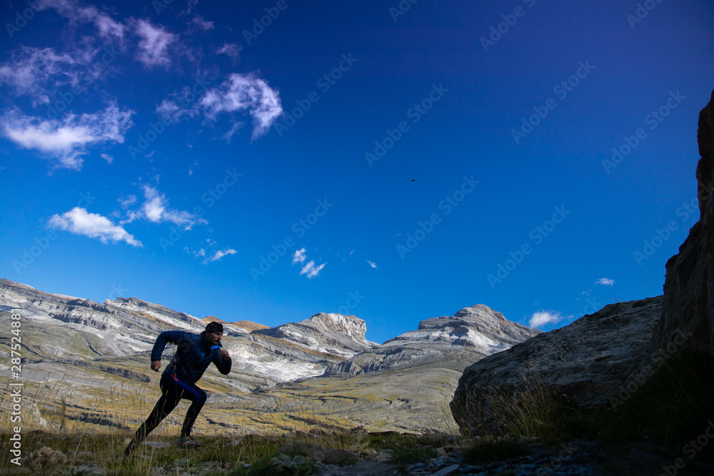 Obraz premium athlete boy running down the mountain in a race