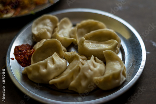 Nepalese traditional dumpling momos steamed served with tomato chutney, schezwan sauce in himalayas