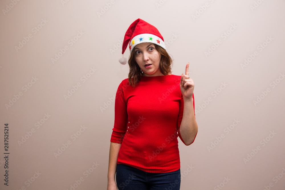 happy girl in santa hat in red blouse on white background happy girl in santa hat in red blouse on white background