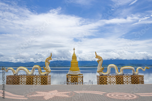 Naga statue with a bright sky and lake background photo