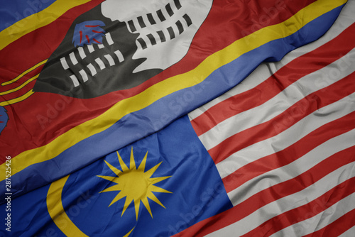 waving colorful flag of malaysia and national flag of swaziland.