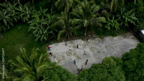 4K Aerial Footage of Children Playing A Game of Basketball at a local basketball hoop in the jungle on a tropical island in the Philippines Siargao photo