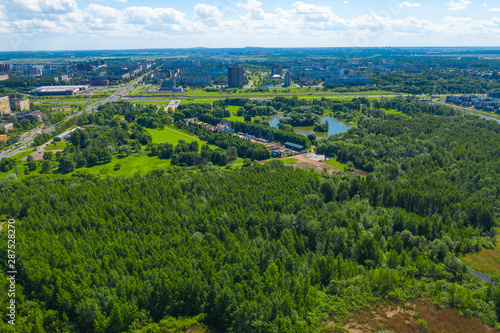 Aerial view of south seaside park on southwest part of St. Petersburg city. Summer, a lot of green trees, blue sky, clouds. Russia