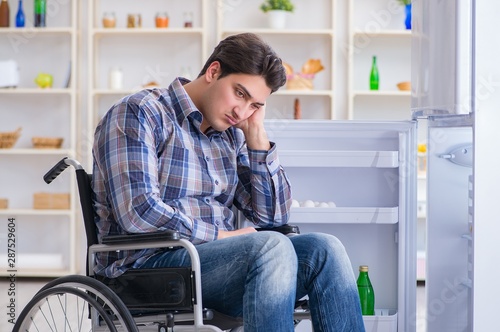 Young disabled injured man opening the fridge door © Elnur