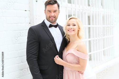 Beautiful couple wearing elegant clothes are ready for party.