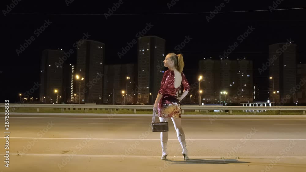 adult woman is engaged in prostitution at night. prostitute awaiting