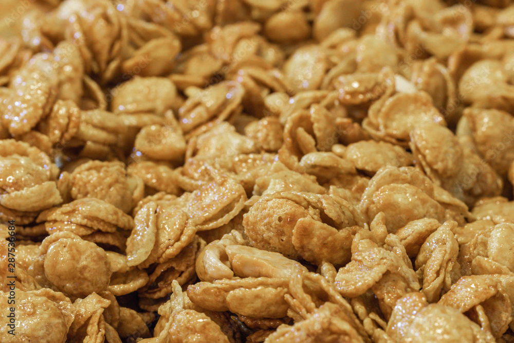 Close up delicious cereal caramel cornflakes warm tone background. A Breakfast cereal made by flakes of corn. Close up delicious cereal caramel cornflakes warm tone background. A Breakfast cereal made by flakes of corn.