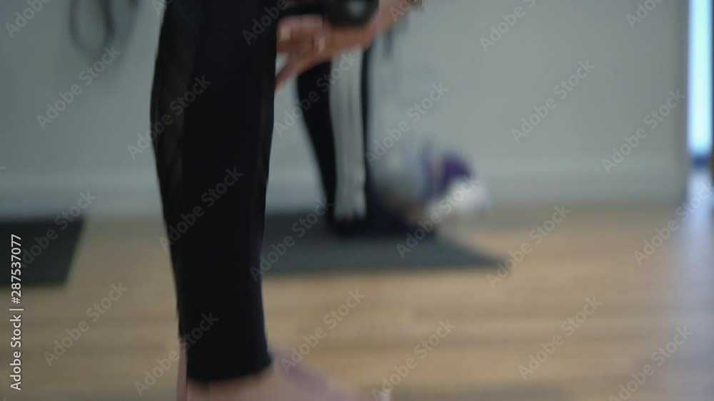 A close up of a lady working out in a gym, Showing her legs, feet and hands with small dumbbells and bracelets and watch in her hands A close up of a lady working out in a gym, Showing her legs, feet and hands with small dumbbells and bracelets and watch in her hands