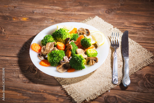 Delicious vegetarian food in a dish vegetable meal. Broccoli, carrots and mushrooms photo