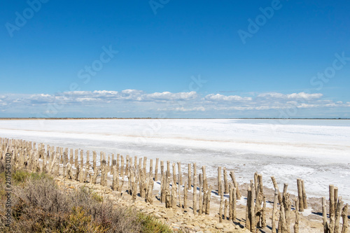 Fototapeta Naklejka Na Ścianę i Meble -  Camargue white salt flat lake, etang salt water lagoon surrounded by sand dunes, Southern France
