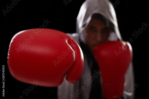 Boxer with red boxing glove punches air.