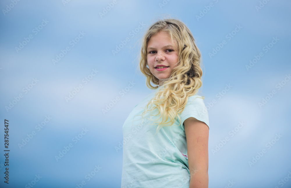 Hairdresser salon services. Little girl with long curly hair sky background. Prevent split ends. Girl with healthy natural curly hair. Curly and gorgeous hairstyles. Beauty procedure. Adorable kid Hairdresser salon services. Little girl with long curly hair sky background. Prevent split ends. Girl with healthy natural curly hair. Curly and gorgeous hairstyles. Beauty procedure. Adorable kid