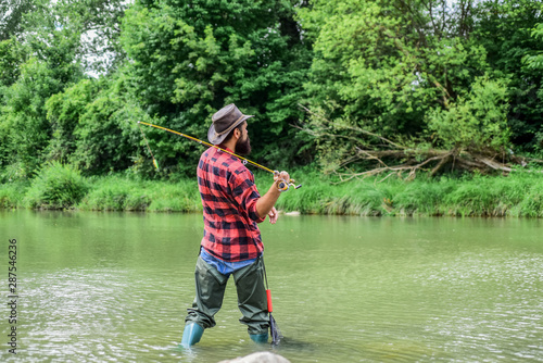 Fisherman catching fish. Teach man to fish. Fishing outdoor sport. Fishing hobby. Calm and tranquil. Patience and waiting. Fly fishing may well be considered most beautiful of all rural sports