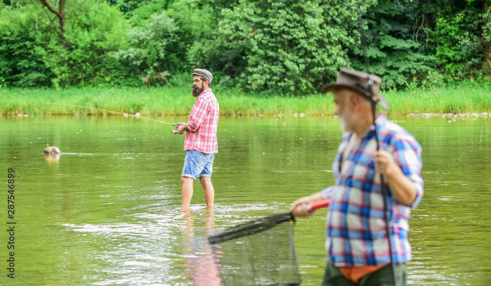 competitors. male friendship. family bonding. summer weekend. two fishermen with fishing rods, selective focus. mature man fisher. hobby and sport activity. son and father fishing competitors. male friendship. family bonding. summer weekend. two fishermen with fishing rods, selective focus. mature man fisher. hobby and sport activity. son and father fishing
