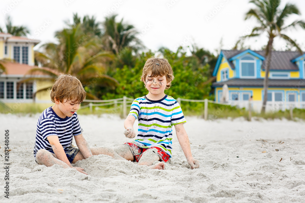 Two little kids boys having fun on tropical beach