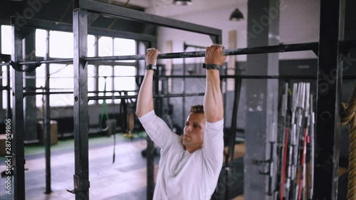 Close up, hendhold. Inverse pull-ups to chest to be fit. Best exercises in the gym. Strong sportsman pulls up on bar in gym and wears lift and grip gear. Daily routine in crossfit gym and everyday