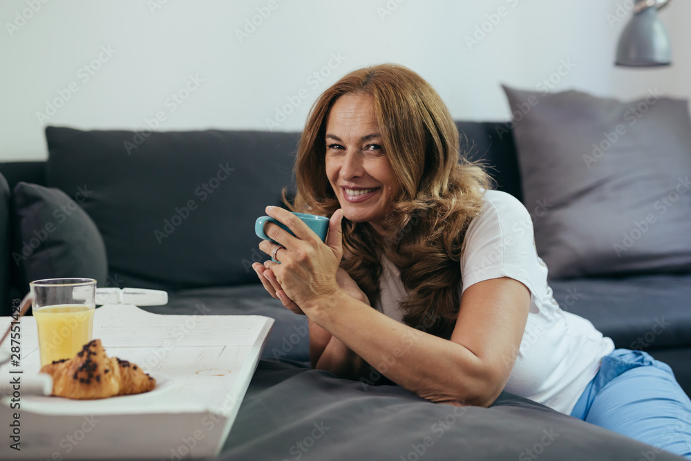 mid age woman enjoying morning coffee in her home