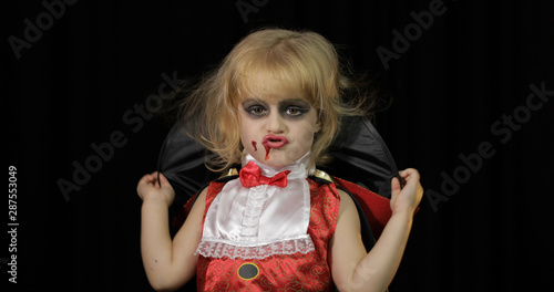 Dracula child. Girl with halloween make-up. Vampire kid with blood on her face