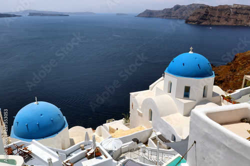 Balcony overlooking the blue domes and white buildings of Santorini looking over the blue Aegean Sea  Greek Islands