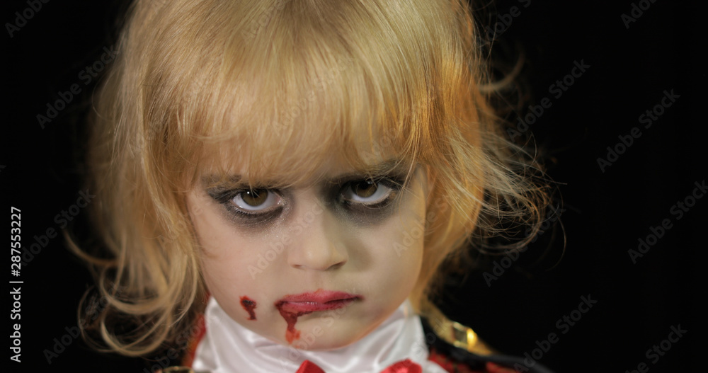 Dracula child. Girl with halloween make-up. Vampire kid with blood on her face Dracula child. Girl with halloween make-up. Vampire kid with blood on her face