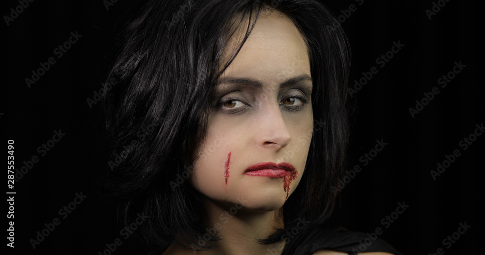 Vampire Halloween makeup. Woman portrait with blood on her face. Vampire Halloween makeup. Woman portrait with blood on her face.