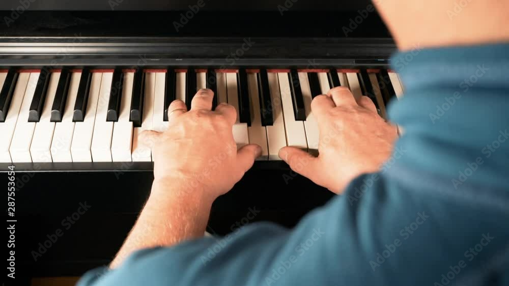Watching a married old man playing on a black piano - over shoulder Watching a married old man playing on a black piano - over shoulder