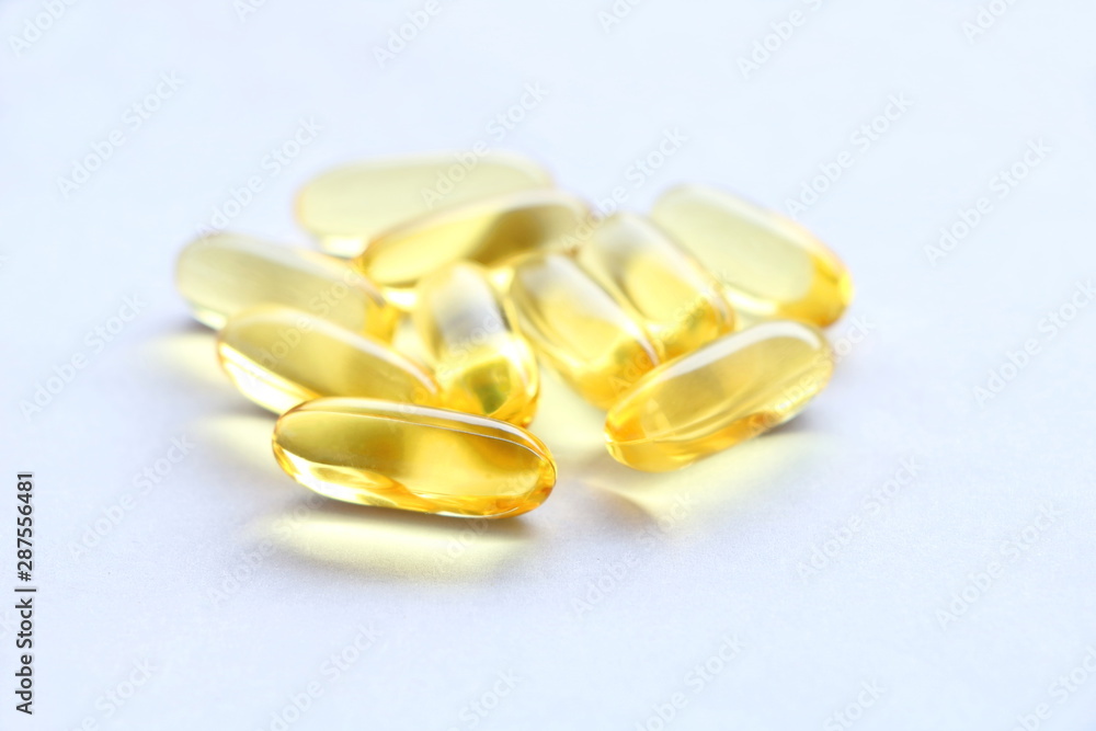 Close up yellow Cod Liver Oil capsule on white background, fish oil is a dietary supplement derived from liver of cod fish, have omega-3 fatty acids, EPA, DHA, vitamin A and D Close up yellow Cod Liver Oil capsule on white background, fish oil is a dietary supplement derived from liver of cod fish, have omega-3 fatty acids, EPA, DHA, vitamin A and D