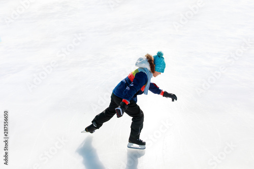 child skating on ice in winter nature