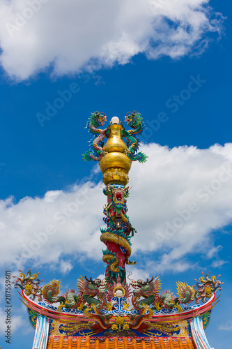Dragon head statue at Chinese shrine over blue sky
