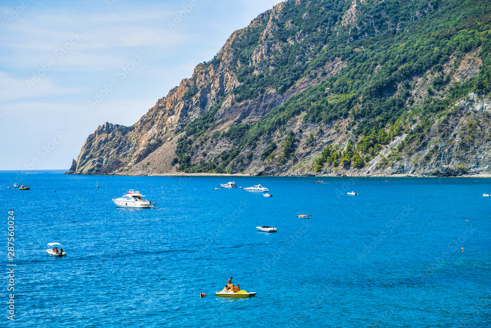 Monterosso al Mare, La Spezia province, Italy - August 17, 2019: city beach in the summer season / big beach in Liguria / vacation in Italy / protruding cliffs in the sea, boats and yachts