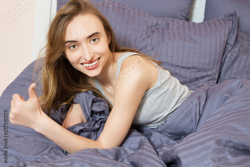 Good sleep concept - Woman in bed showing like sign no insomnia.