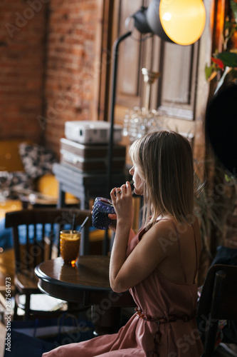 Slika na platnu beautiful pensive calm relaxed girl blonde sits at a table in a retro vintage st