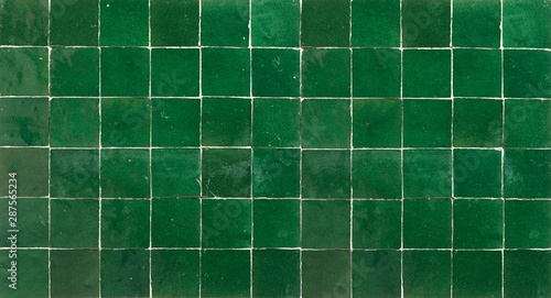 Old retro dark green ceramic tile texture background. Dark green square tiled wall.