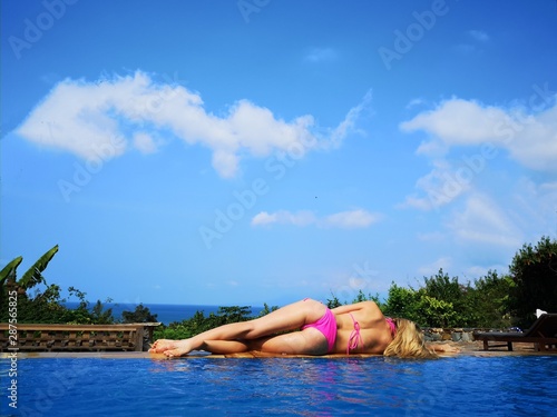 woman relaxing on inflatable mattress in swimming pool