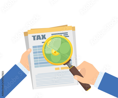 business hands with magnifier above tax document