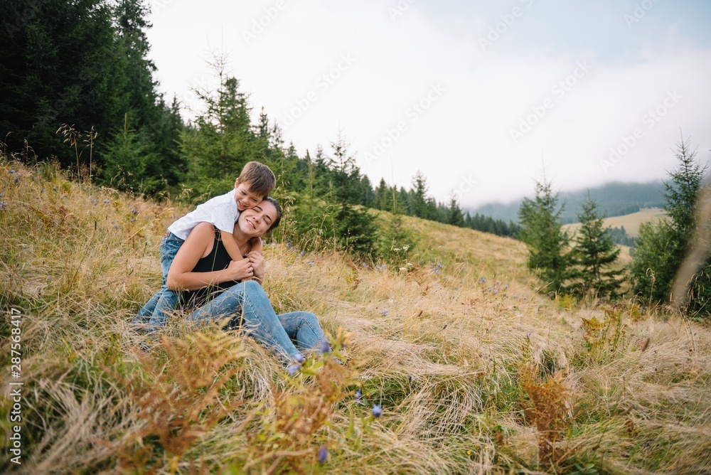 Young mom with baby boy travelling. Mother on hiking adventure with child, family trip in mountains. National Park. Hike with children. Active summer holidays. Fisheye lens