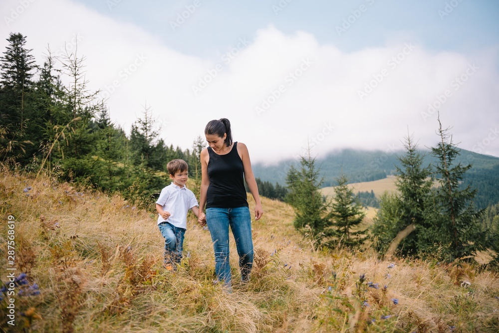 Young mom with baby boy travelling. Mother on hiking adventure with child, family trip in mountains. National Park. Hike with children. Active summer holidays. Fisheye lens