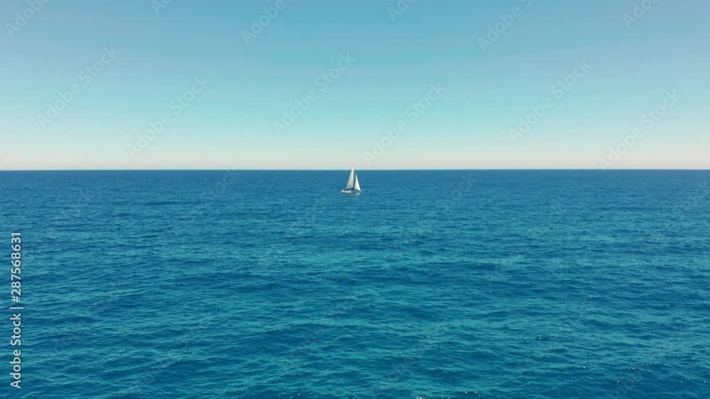 Sailboat in the ocean. White sailing yacht in the middle of the boundless ocean. Aerial view. Sailboat in the ocean. White sailing yacht in the middle of the boundless ocean. Aerial view.
