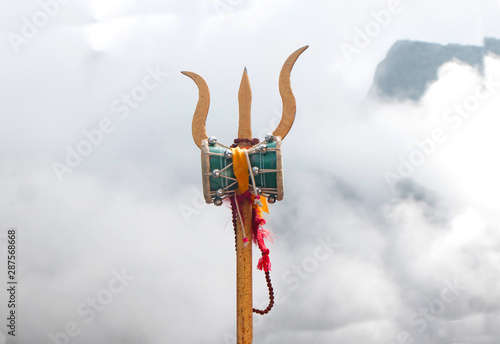 Trident weapon of lord shiva placed ahead of a cloudy mountain-image photo