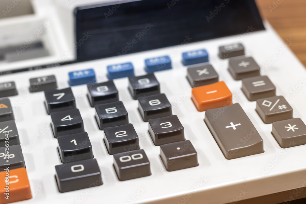 Close up white calculator on wooden table. Finances business savings and accounting concept or Education idea. Close up white calculator on wooden table. Finances business savings and accounting concept or Education idea.