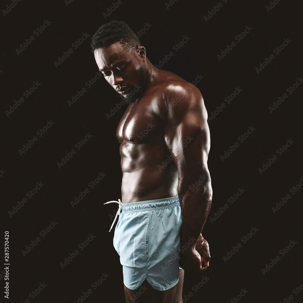 Fototapeta premium Side triceps pose perfomed by black bodybuilder