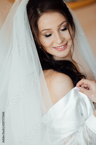 Bride enjoying her great day. Bride posing with veil. Bride with elegant hairstyle and makeup eyes closed. Wedding portrait of a cute girl.  Portrait of a beautiful young wedding girl bride.