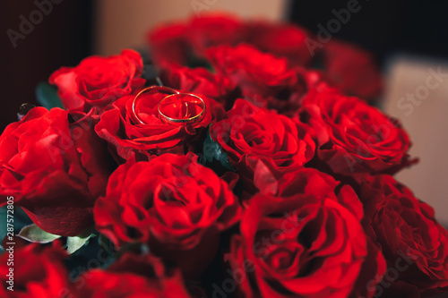 wedding rings on a bouquet of red roses
