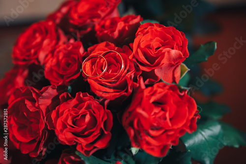 wedding rings on a bouquet of red roses