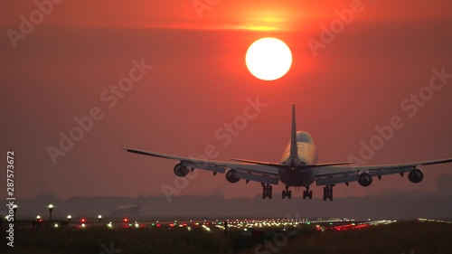 Big airplane landing at beautiful sunrise